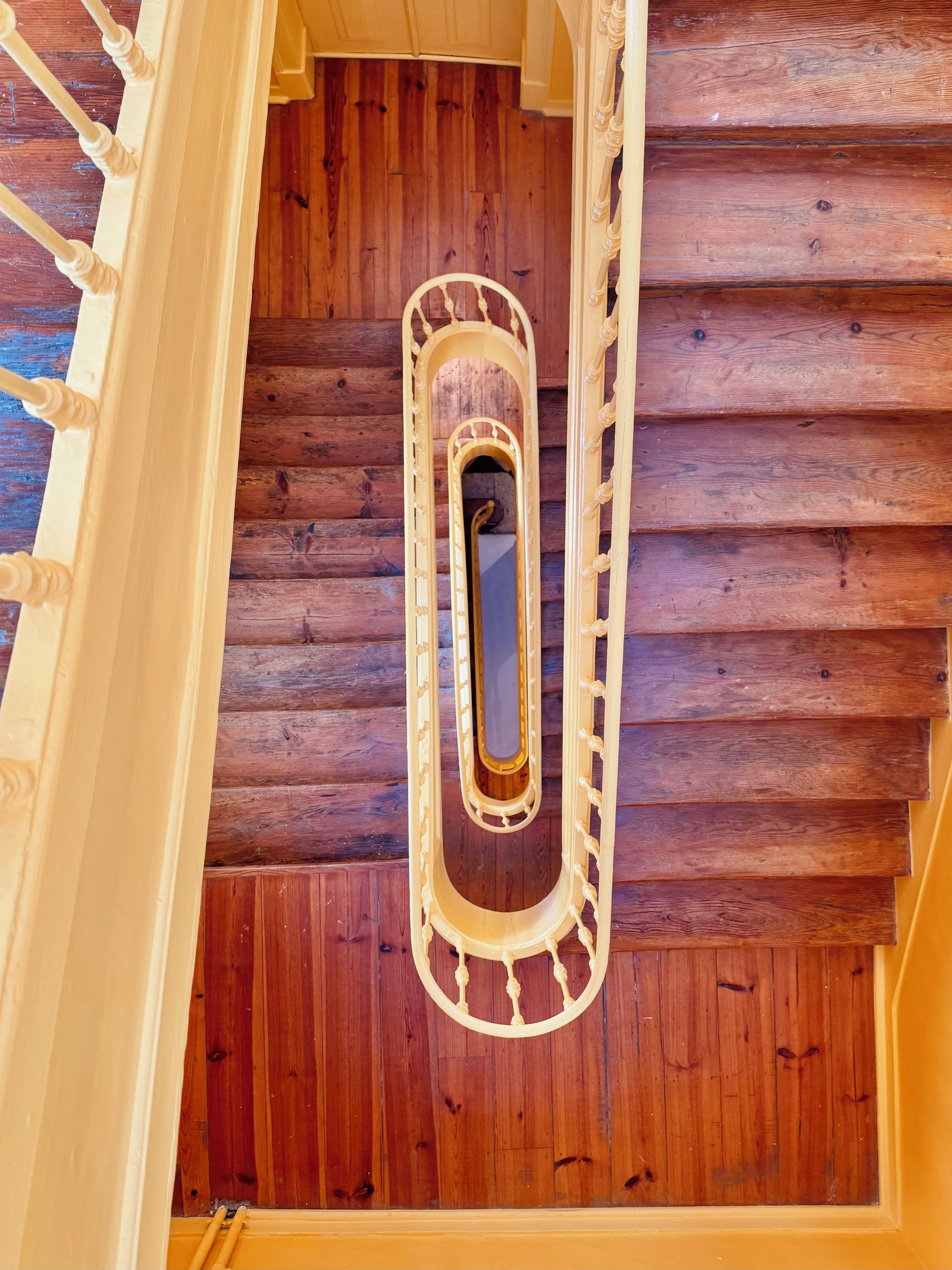 Eine Holztreppe mit einer zentralen Wendeltreppe und einem Holzboden.