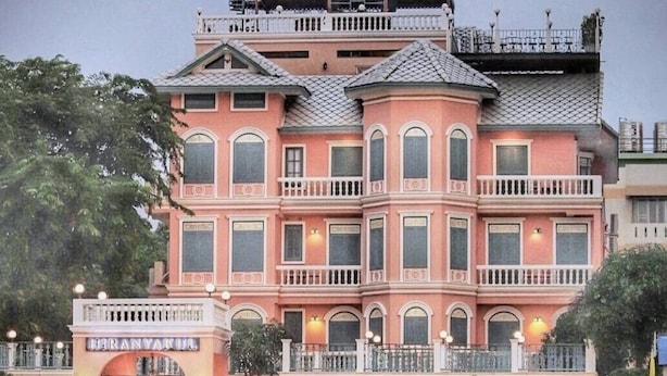 Un hotel a più piani con facciata rosa, balconi e vista sul lungomare.