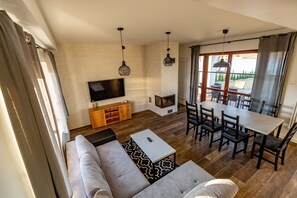 A modern living room with a sofa, dining table, and TV.