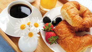 A breakfast tray with croissants, strawberries, blackberries, a coffee cup, and a glass of orange juice. - Velantia Vaticano - Guesthouse (Rome)