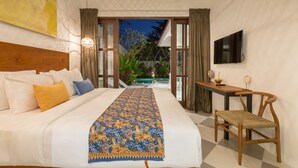 A bedroom with a large bed, a TV, and a view of a pool. - Villa CJ (Seminyak)