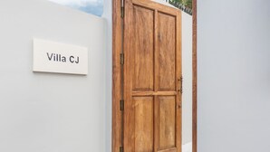 A wooden door with a nameplate reading "Villa CJ" on a white wall. - Villa CJ (Seminyak)