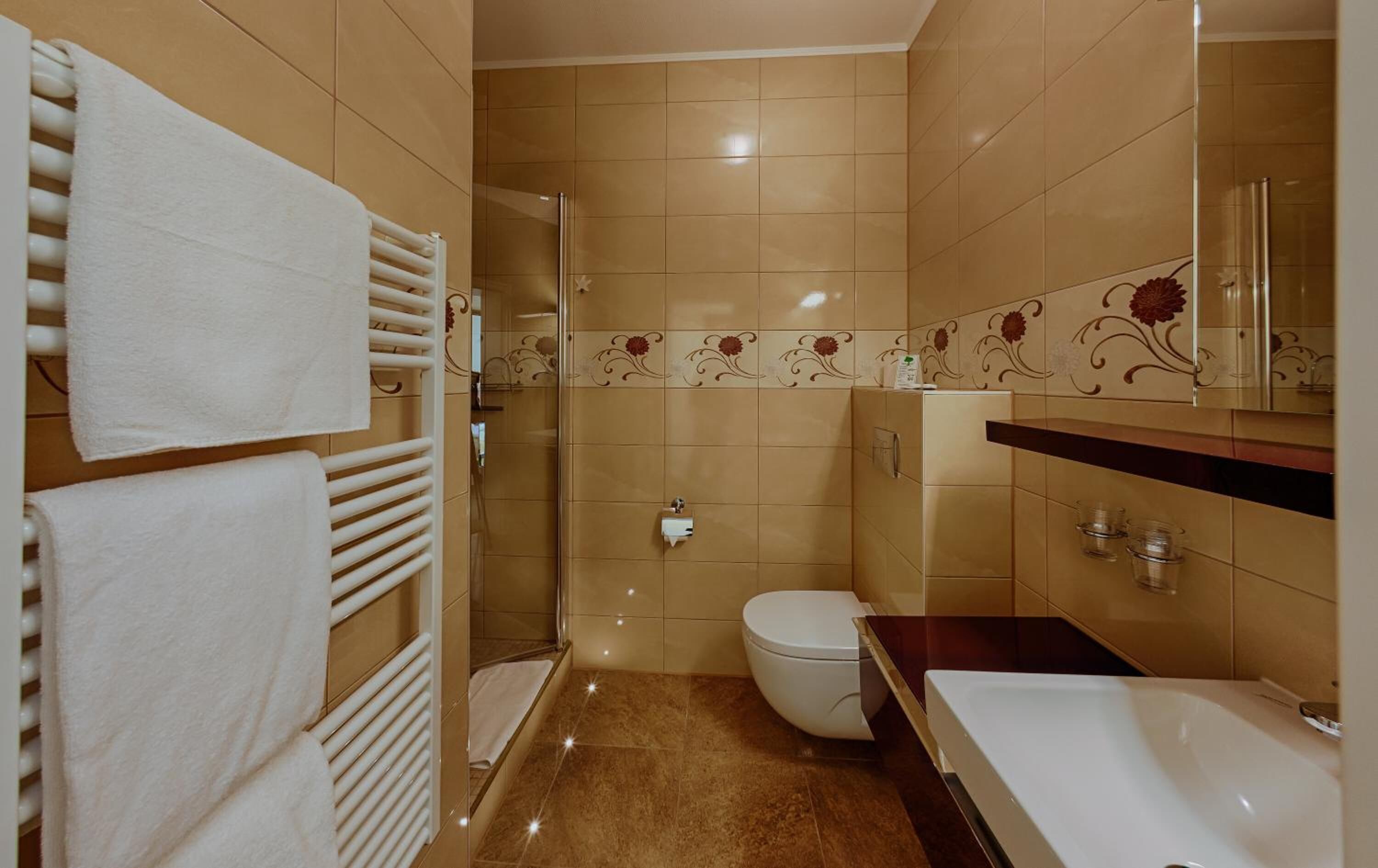 A bathroom with a toilet, sink, and shower.