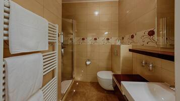 A bathroom with a toilet, sink, and shower.