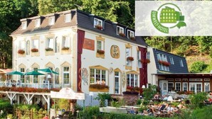 Un hôtel de style européen traditionnel, avec plusieurs étages, des espaces de détente en plein air et un jardin.