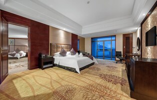 Habitación de hotel con una cama grande, un escritorio, un televisor y vistas al exterior.