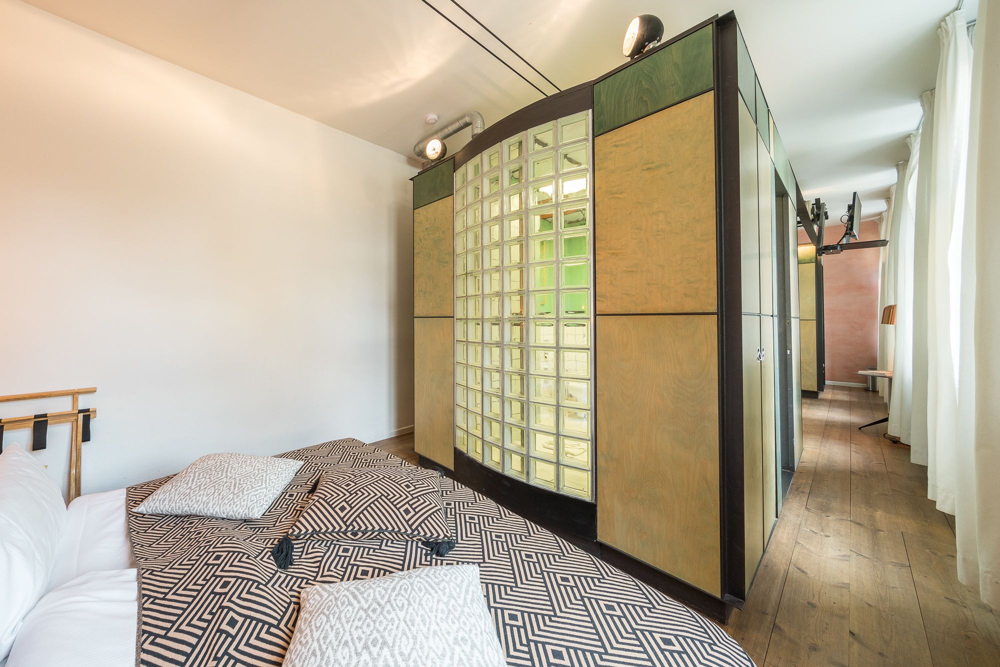 Ein Hotelzimmer mit einem Bett, einer großen Schiebetür mit Gittermuster und Holzboden.