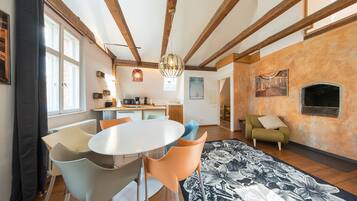 A spacious living area with a dining table, chairs, a sofa, and a fireplace.