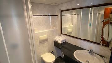 A modern bathroom with a shower, toilet, and sink.