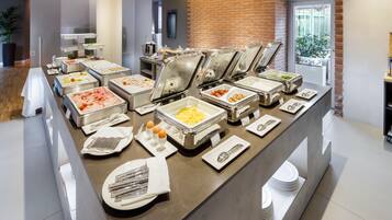 Una mesa de buffet con diferentes alimentos y utensilios.