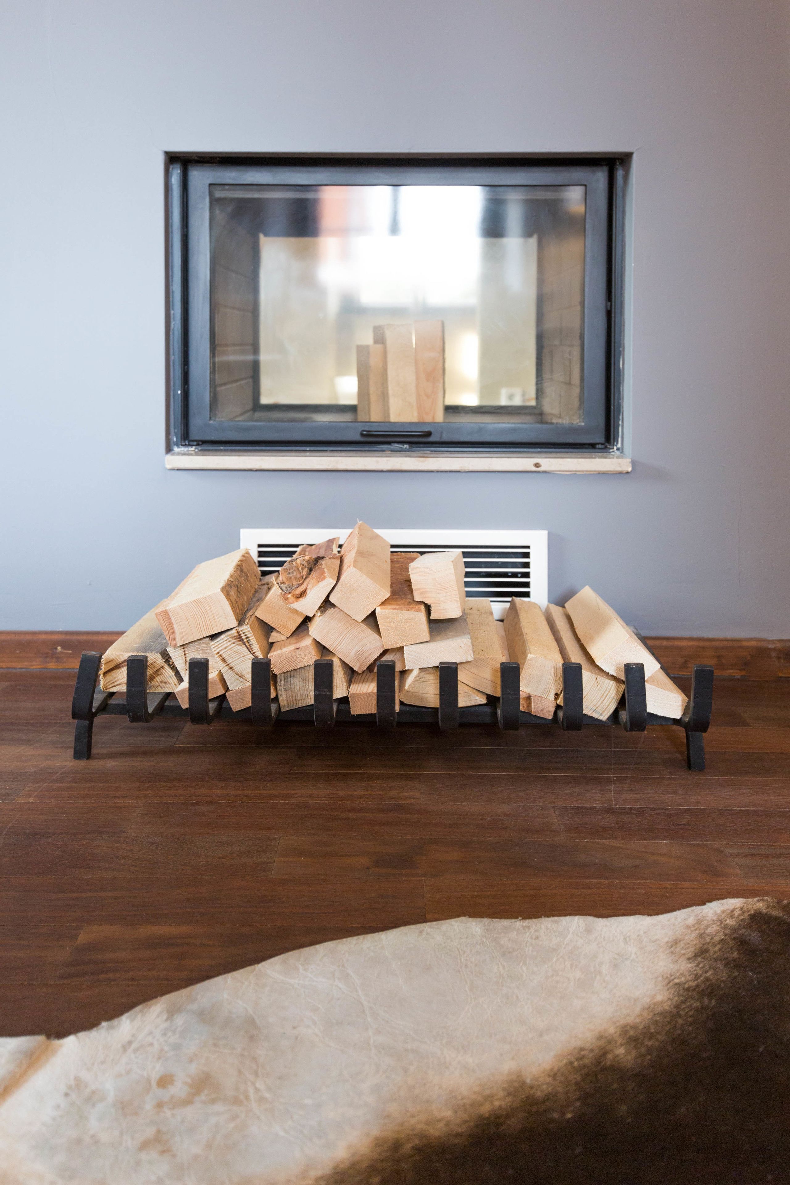 A room with a fireplace, a window, and a radiator.