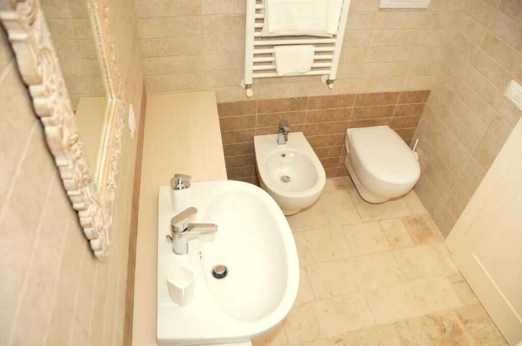 A bathroom with a sink, bidet, and toilet.