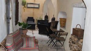 A cozy outdoor seating area with a sofa, chairs, a table, and a grill. - Maison Anila (Barjac)