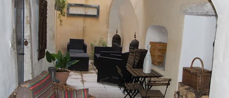 A cozy outdoor seating area with a sofa, chairs, a table, and a grill.