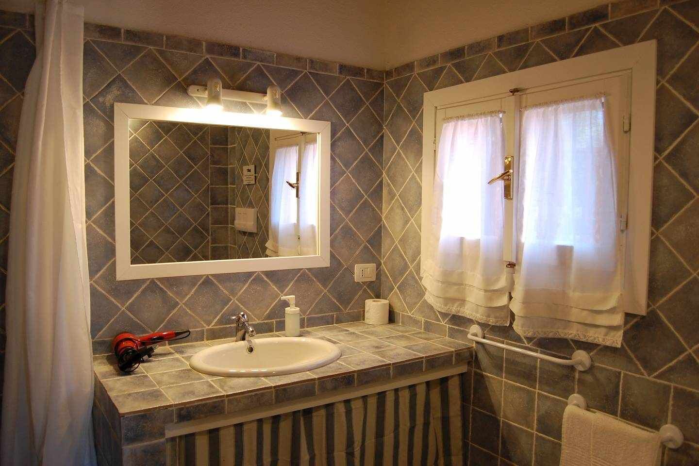 A bathroom with a sink, mirror, and towel rack.