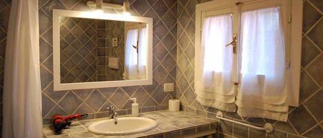 A bathroom with a sink, mirror, and towel rack.