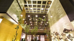 A modern interior with a high ceiling, geometric ceiling design, and hanging lights. - Golden Pearl Tangalle Beach (Tangalle)