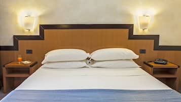 A hotel room with a large bed, two bedside tables, and wall-mounted light fixtures.