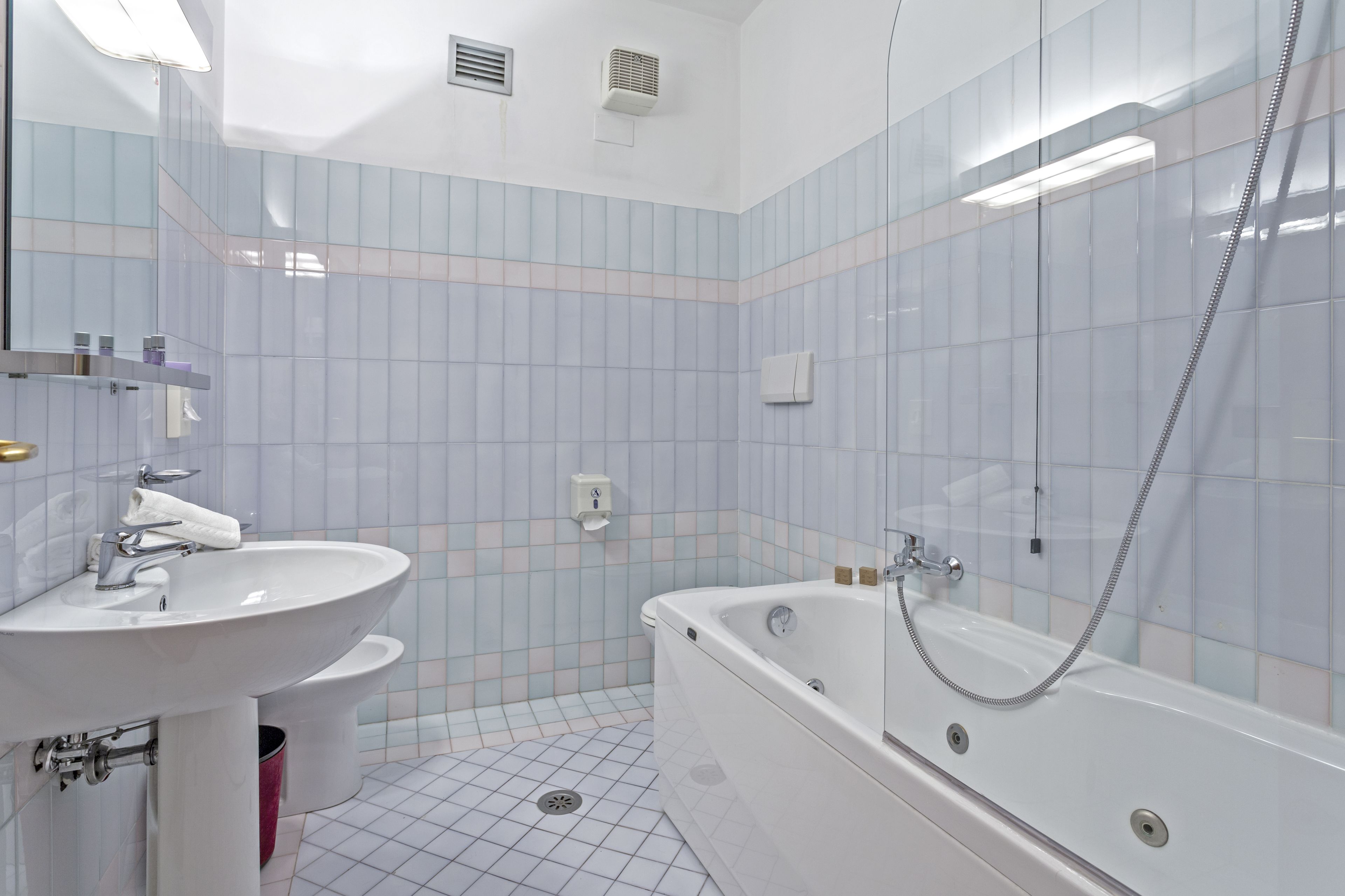 Un baño con lavamanos blanco, bañera y retrete.