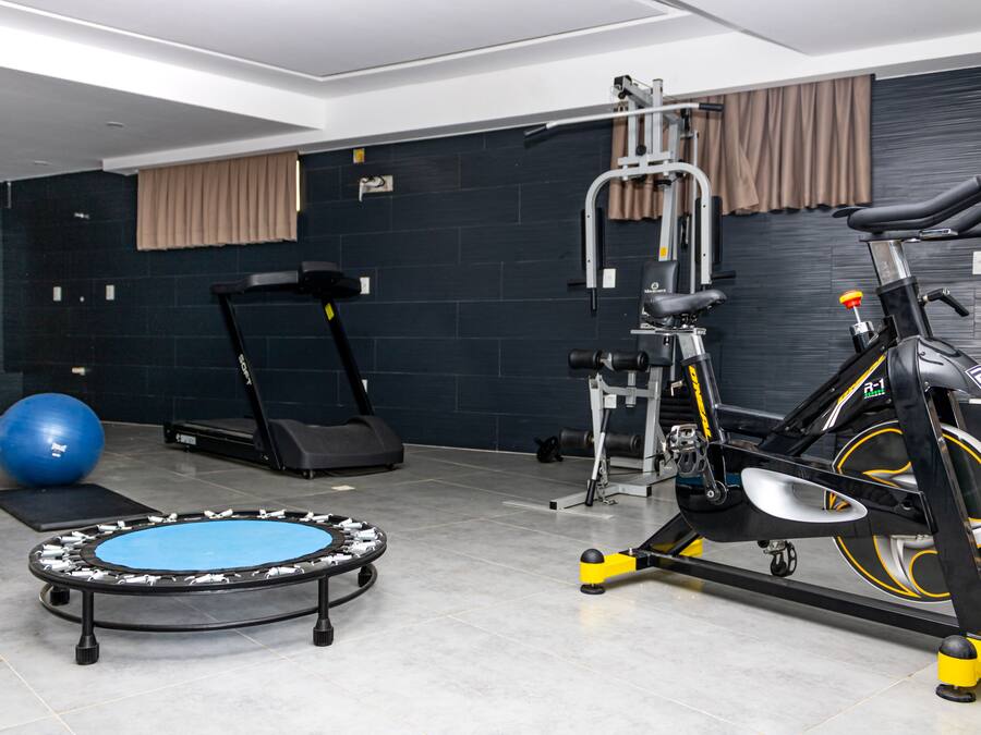 A gym with exercise equipment including a treadmill, elliptical, and a stationary bike.