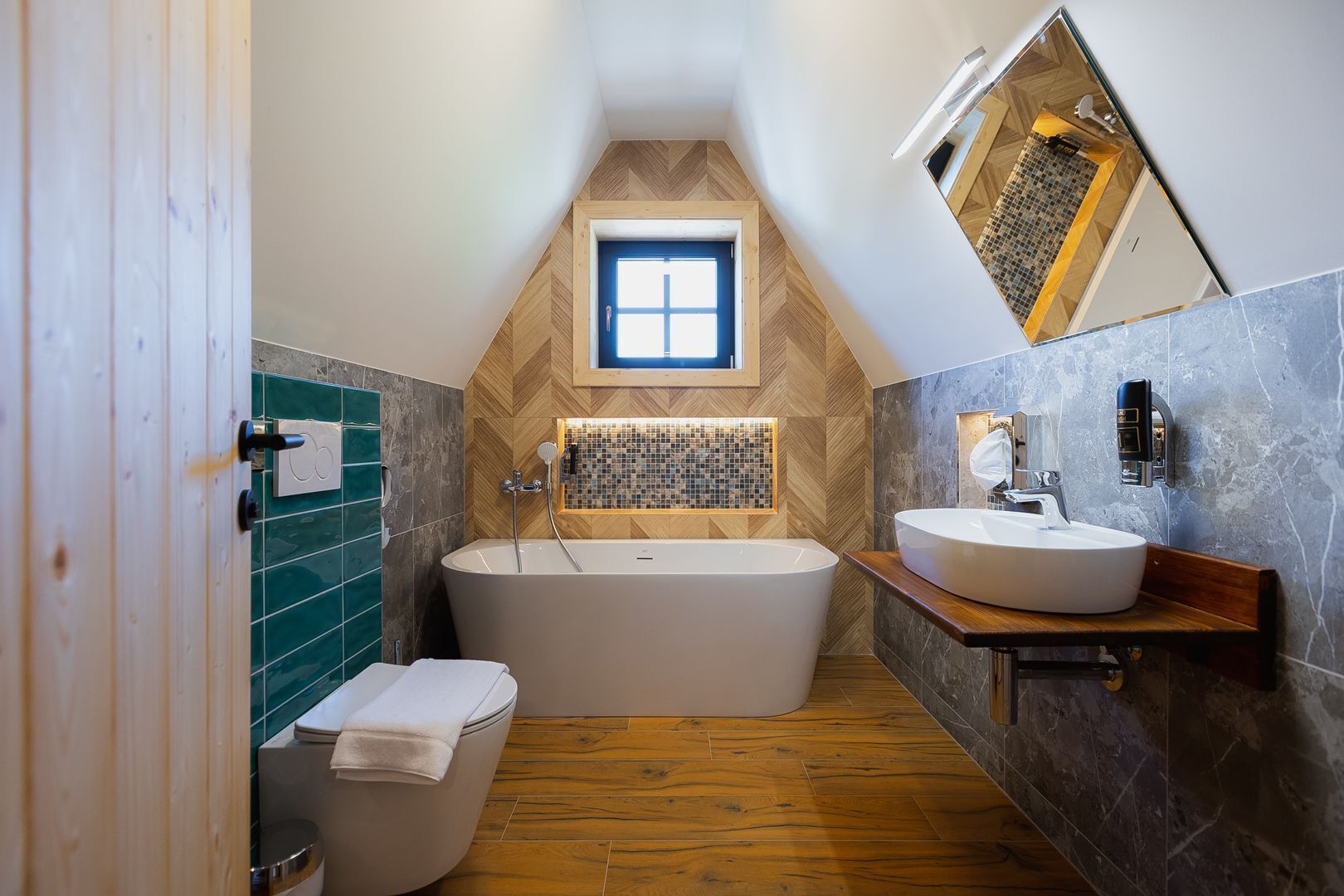 Un baño moderno con una bañera independiente, un inodoro y un lavamanos.