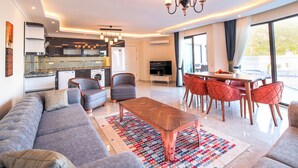 Una sala de estar moderna con un sofá, una mesa de centro y un comedor con sillas.