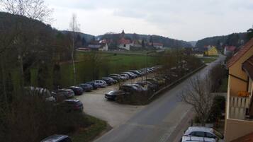 Ein Parkplatz mit Autos, einer Straße und Häusern im Hintergrund.