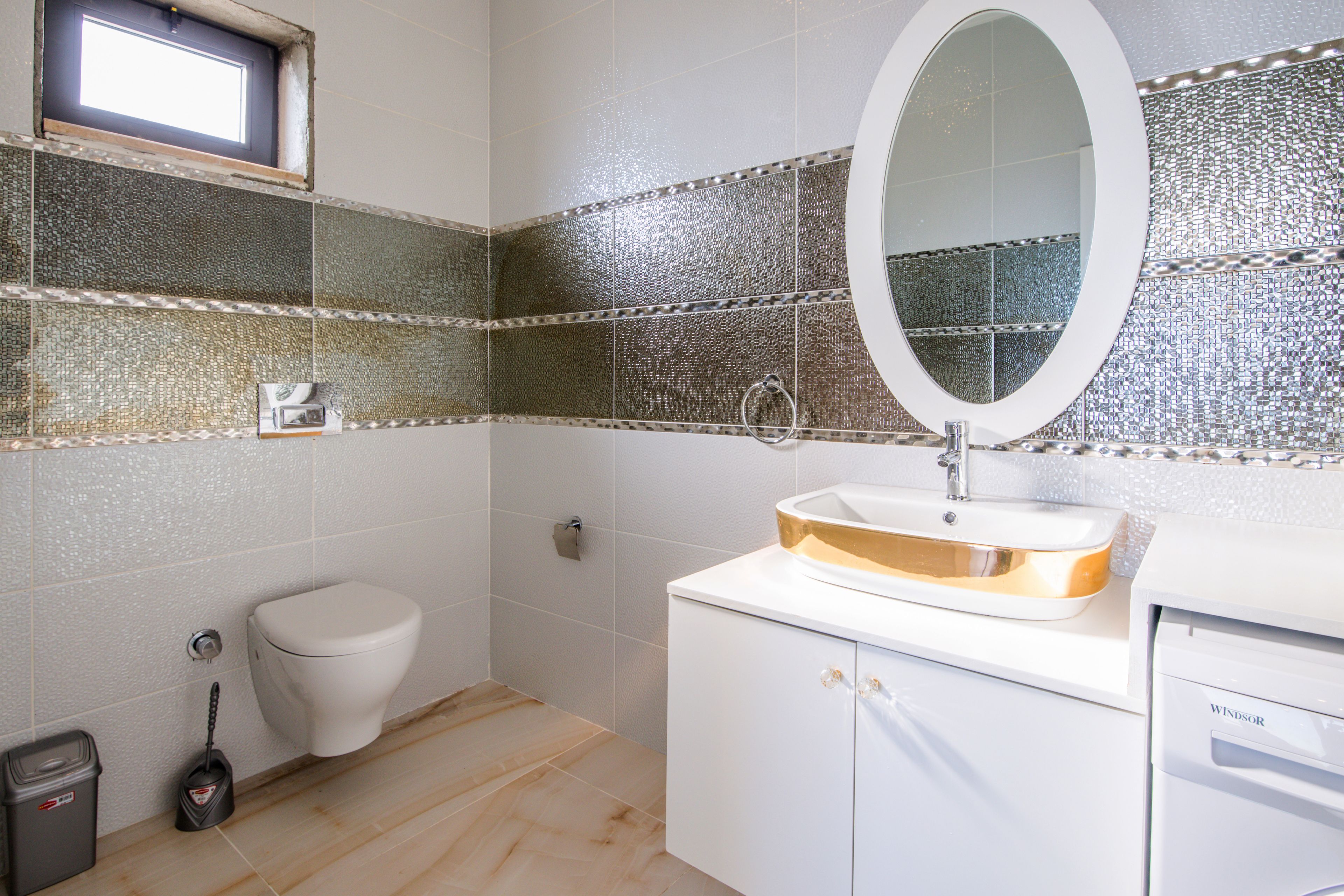 A bathroom with a toilet, sink, and mirror.