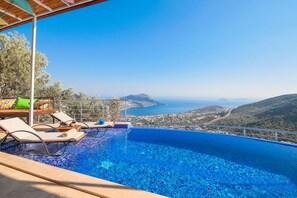Una piscina a sfioro con vista panoramica sul mare e sulle colline.