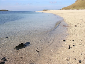 A beach with clear shallow water, pebbles, and a sandy shore. - The Tables Guest House (Dunvegan)