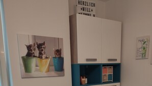 Un comedor con una mesa de madera, sillas color turquesa y un atril para el menú.