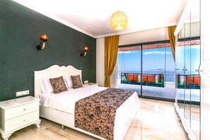 Un dormitorio con cama, mesita de noche y vistas a un balcón con una silla.