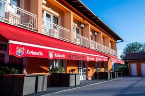Un edificio con un toldo rojo que muestra el nombre "Karlovacko RESTORAN DP".