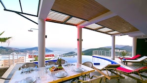 Un coin repas avec une table dressée pour deux personnes, offrant une vue panoramique.