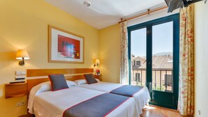 A hotel room with two beds, a painting on the wall, a balcony with a view, and a window with curtains. - Hostal la Chata by Vivere Stays (La Granja de San Ildefonso)