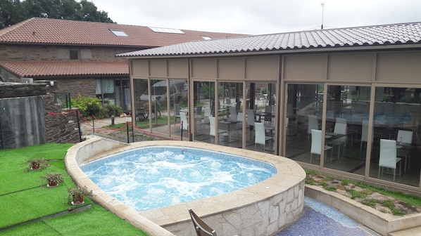 A swimming pool with a stone edge and a glass enclosure.