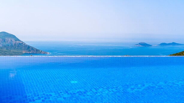 En infinitypool med fri utsikt över havet och avlägsna öar.