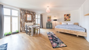 A bedroom with a wooden floor, a bed, a desk, and a chair. - Design Apartments "Potsdam West" (Potsdam)