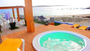 A hot tub on a wooden deck with a view of the beach and boats. - Ouril Agueda (Boa Vista)