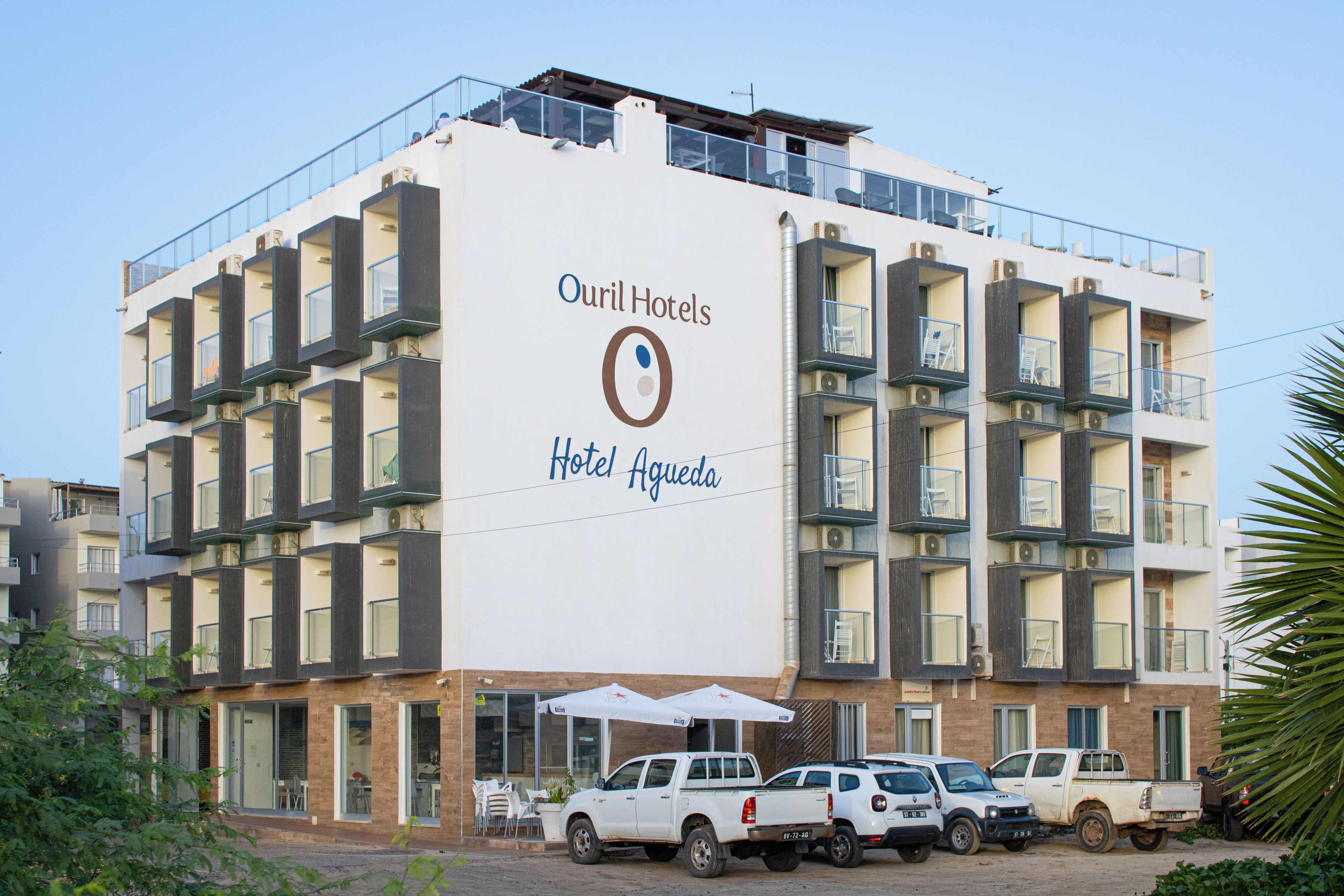 Un immeuble hôtelier à plusieurs étages, doté de balcons et d’une enseigne indiquant « Ourl Hotels Hotel Agueda ».