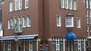 A corner building with a triangular roof and large windows. - Altstadthotel Meppen (Meppen)