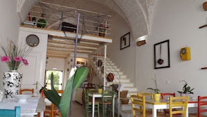Un comedor espacioso con techo alto y una escalera que conduce a un nivel superior.