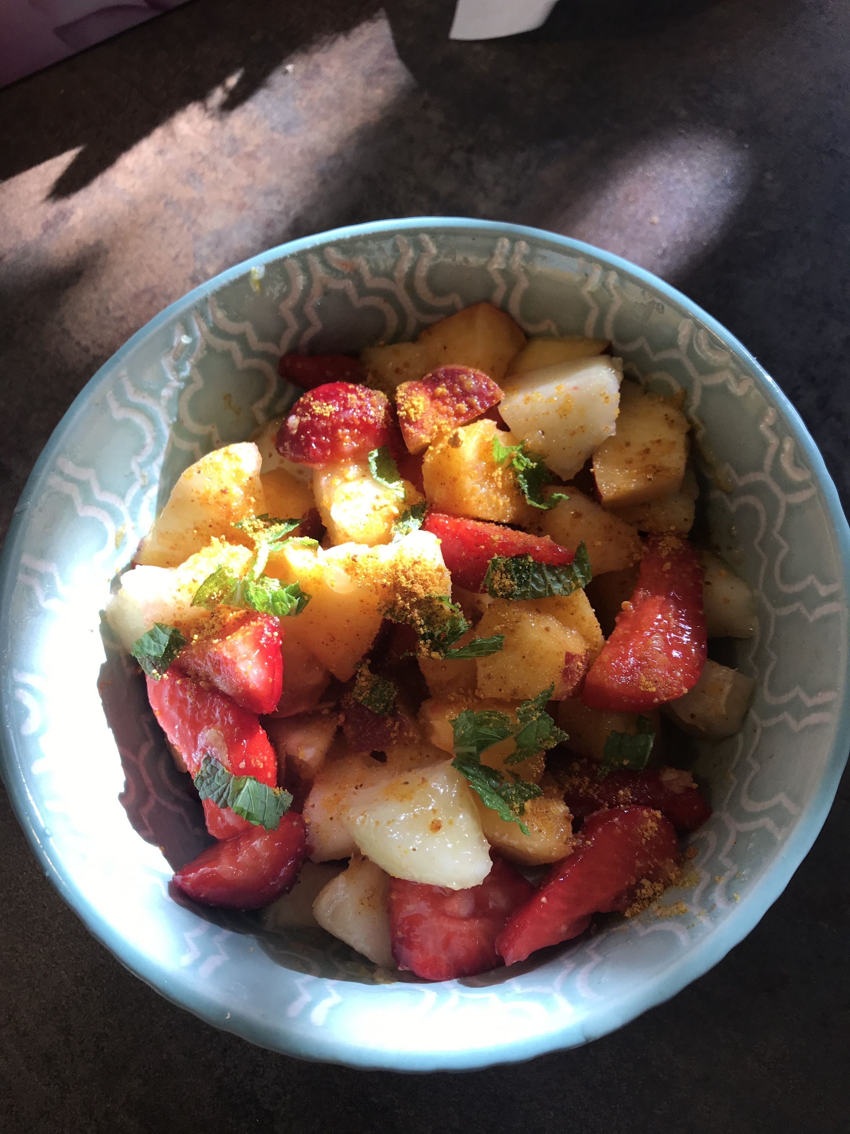 Een schaal eten met aardappelen, tomaten en kruiden.
