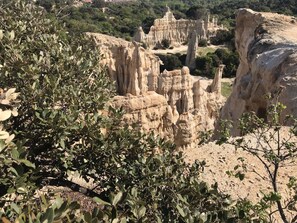 Paesaggio naturale con formazioni rocciose e vegetazione rada.