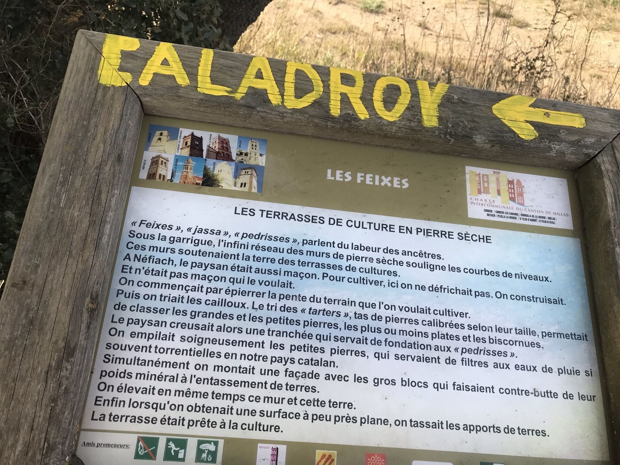 A sign with the name 'CALADROY' and an arrow pointing left. It includes text about 'LES TERRASSES DE CULTURE EN PIERRE SÈCHE' and 'LES FEIXES'.