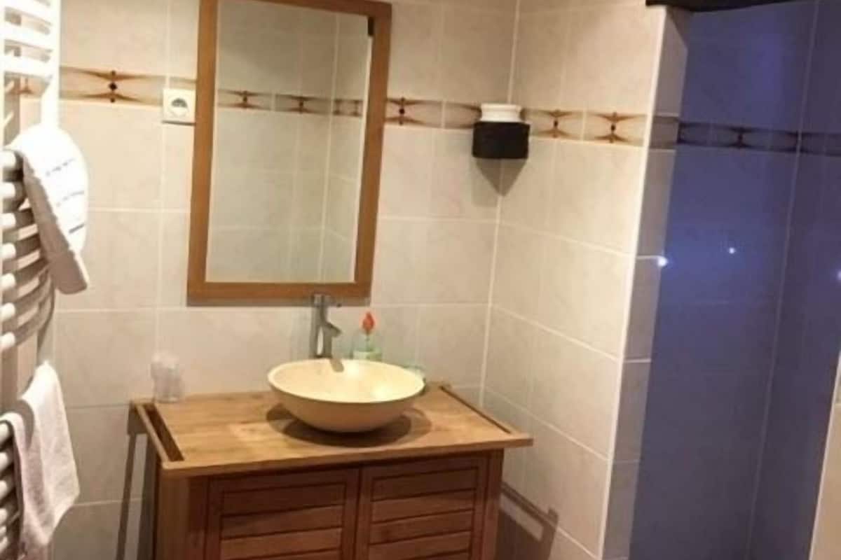 Une salle de bain avec un meuble-lavabo en bois, un évier et un miroir.