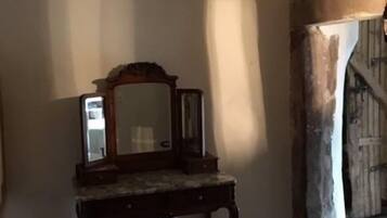 A room with a wooden dresser, a mirror, and a tiled floor.