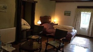 A cozy bedroom with a bed, two chairs, a table, and a radiator. - Chambres d'Hôtes les Hirondelles (Folkling)