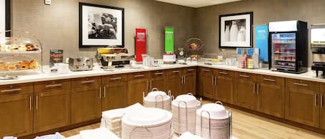 A buffet setup with various food items, beverage dispensers, and neatly arranged serving ware.