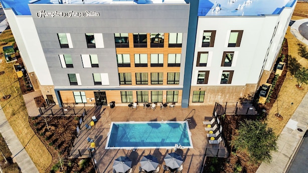 Un Hampton Inn & Suites con piscina en la azotea, zona de estar al aire libre y un diseño arquitectónico moderno.